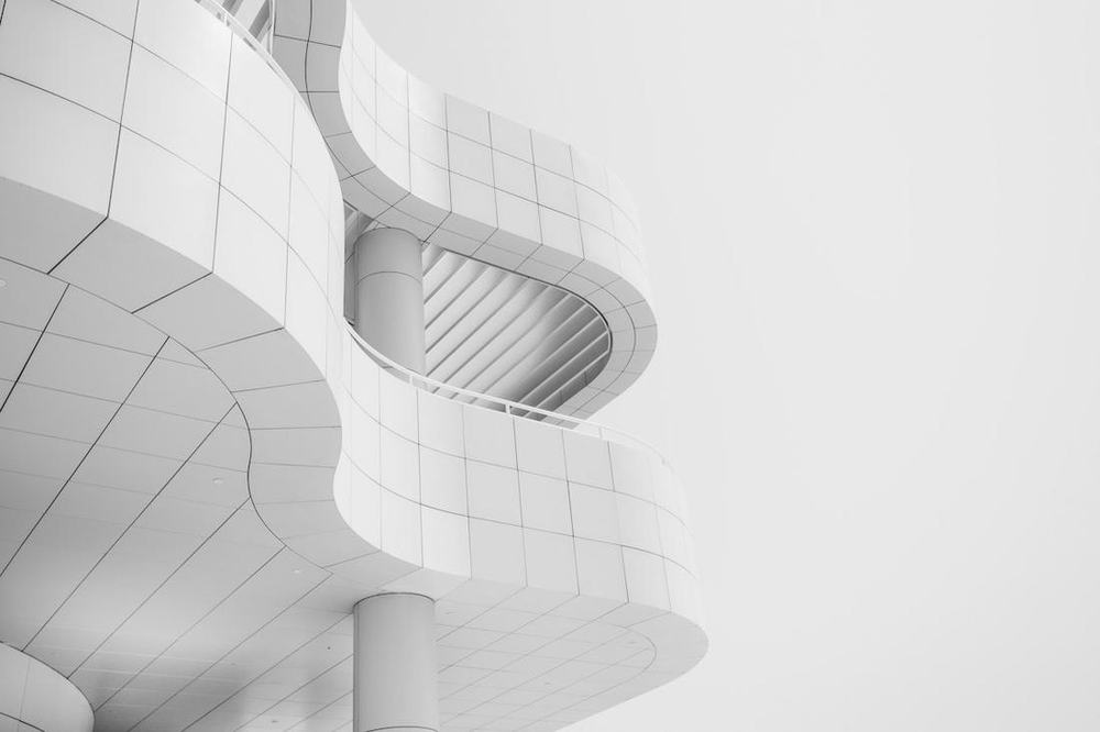 Concrete building facade viewed from below against an open sky.